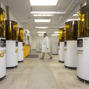 Scientist walking through cooridor of Argen machines
